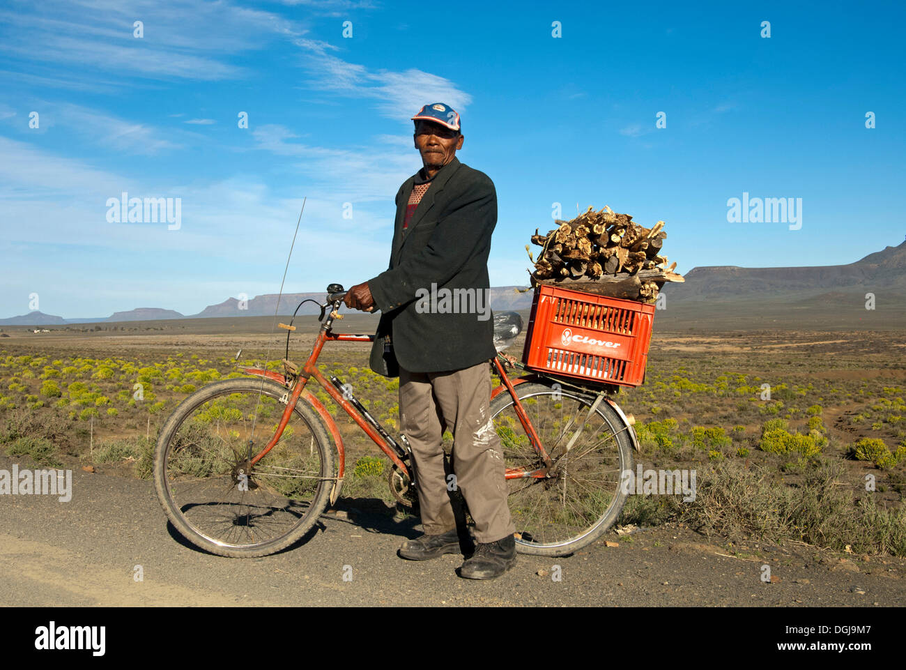 Local man with a bicycle and a box of firewood on the luggage rack, near Calvinia, Northern Cape Province, South Africa, Africa Stock Photo