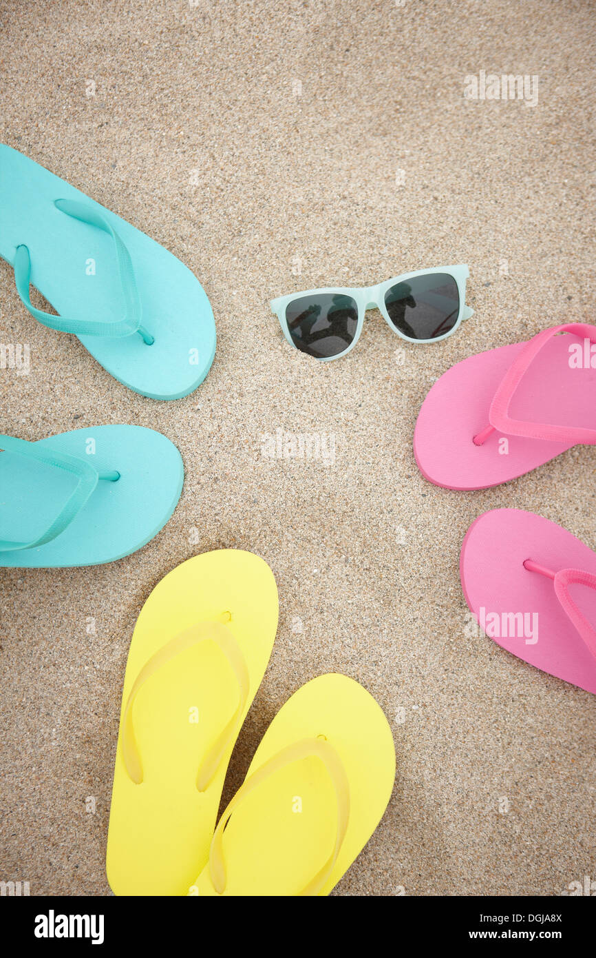 three pairs of flip flops on the beach with sun glasses Stock Photo - Alamy