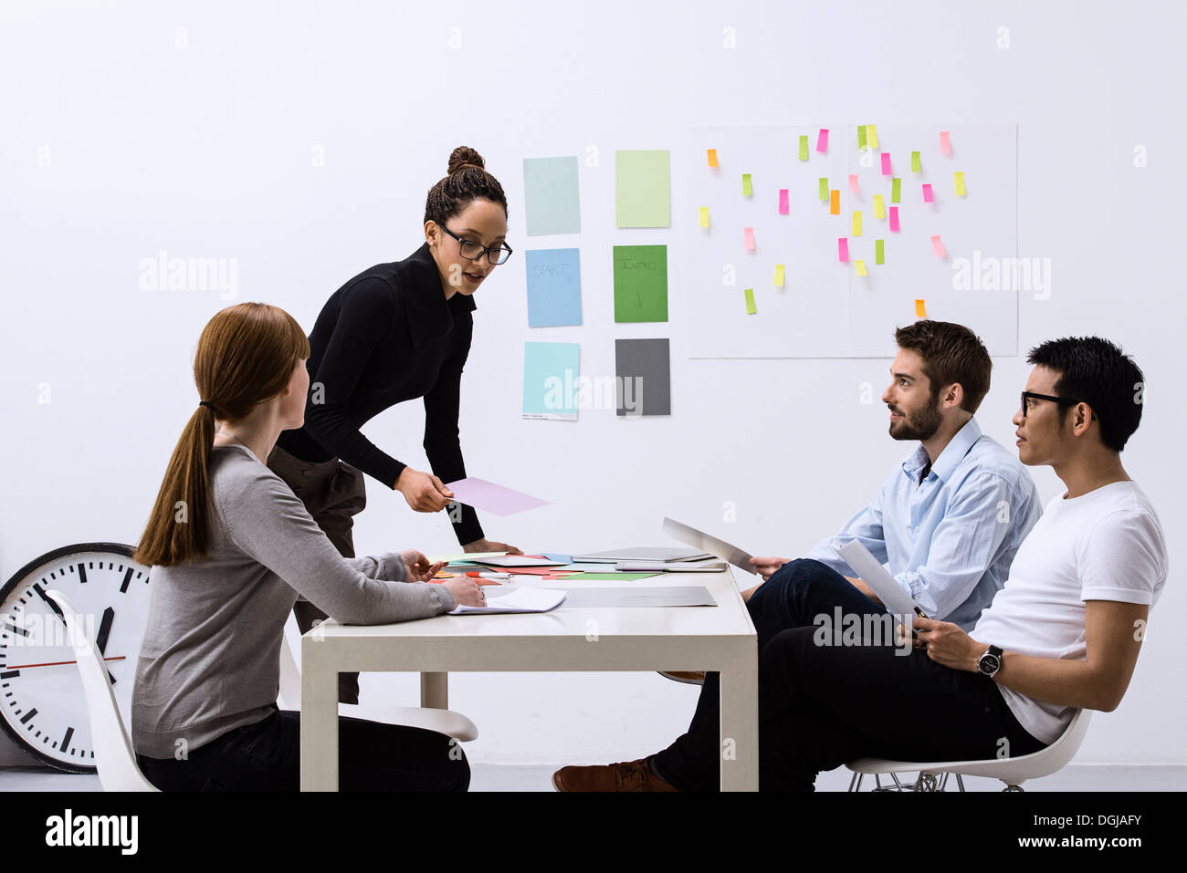 Design team sitting at table discussing ideas Stock Photo - Alamy