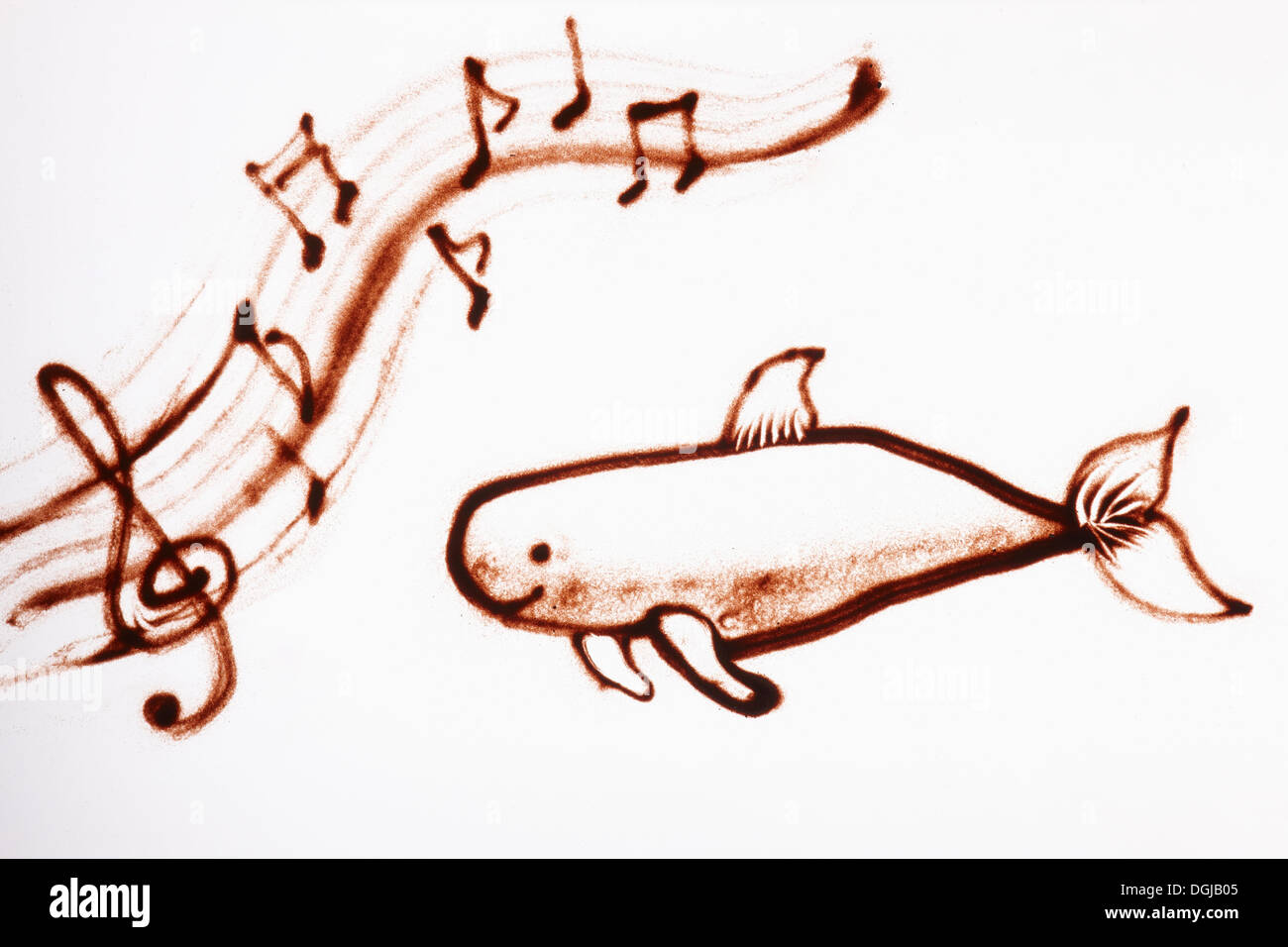 a sand drawing of a whale singing Stock Photo