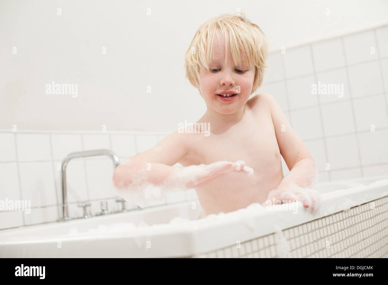 Boy looking at soapsuds in the bathtub Stock Photo