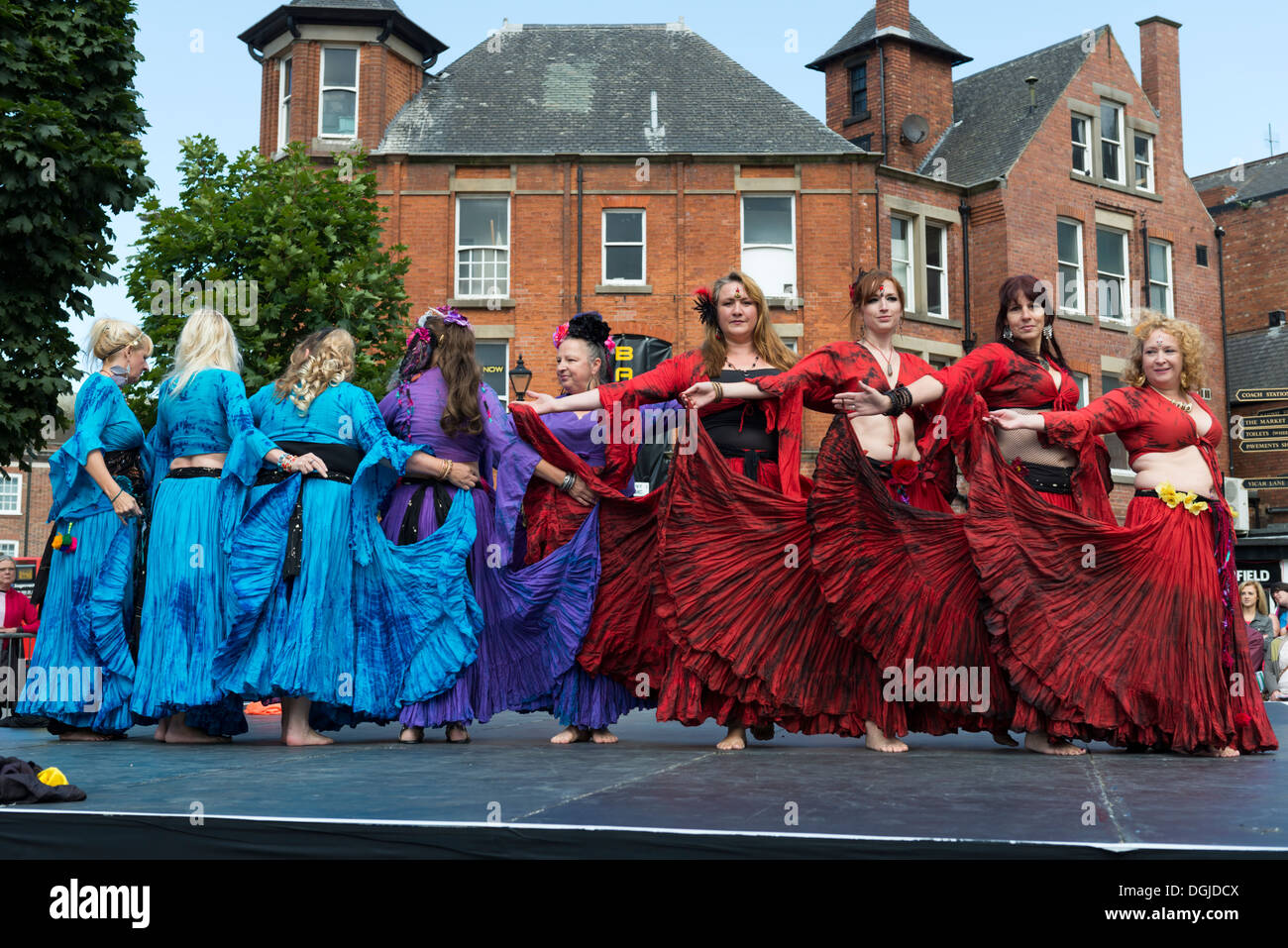 Women dancing on a stage in the open air wearing costumes Dance