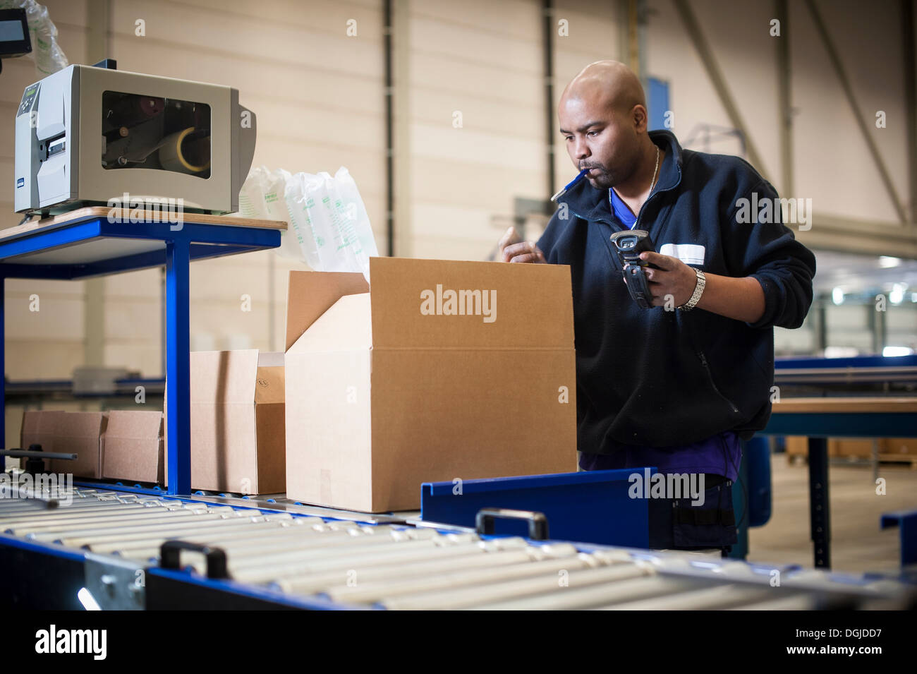 Male warehouse worker checking cardboard box Stock Photo