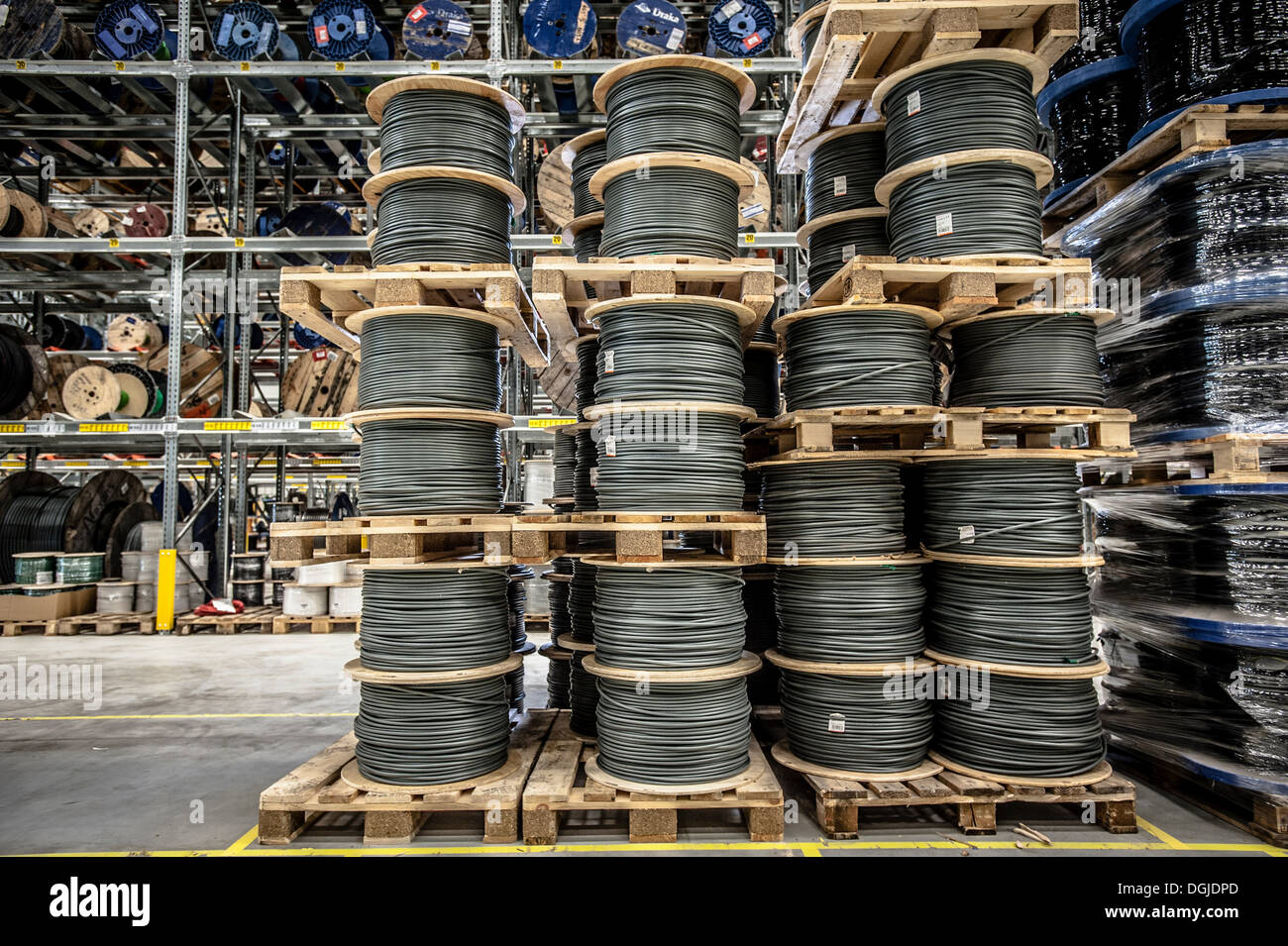 Cable drums stacked on pallets in warehouse Stock Photo