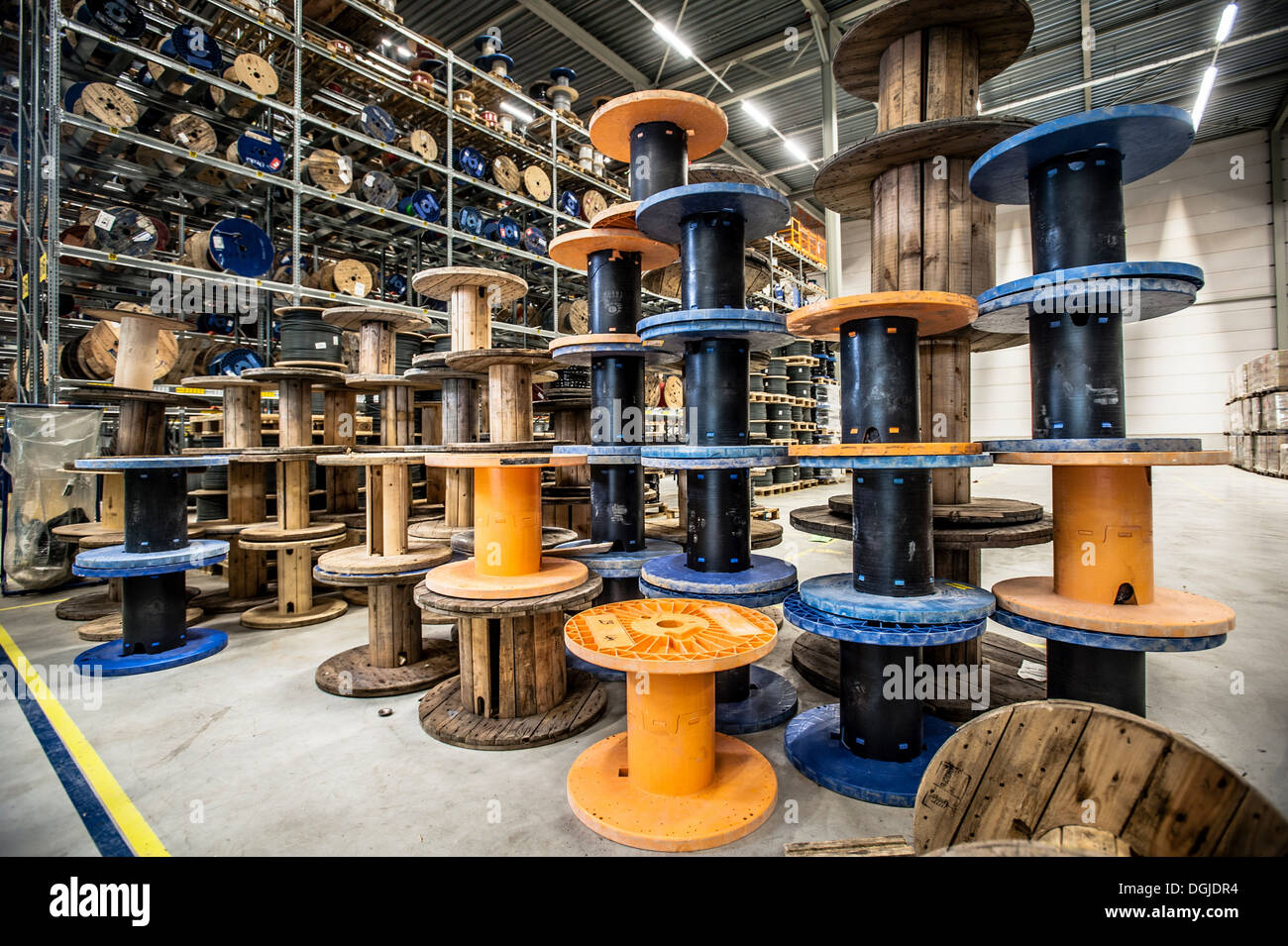 Empty cable drums stacked in warehouse Stock Photo