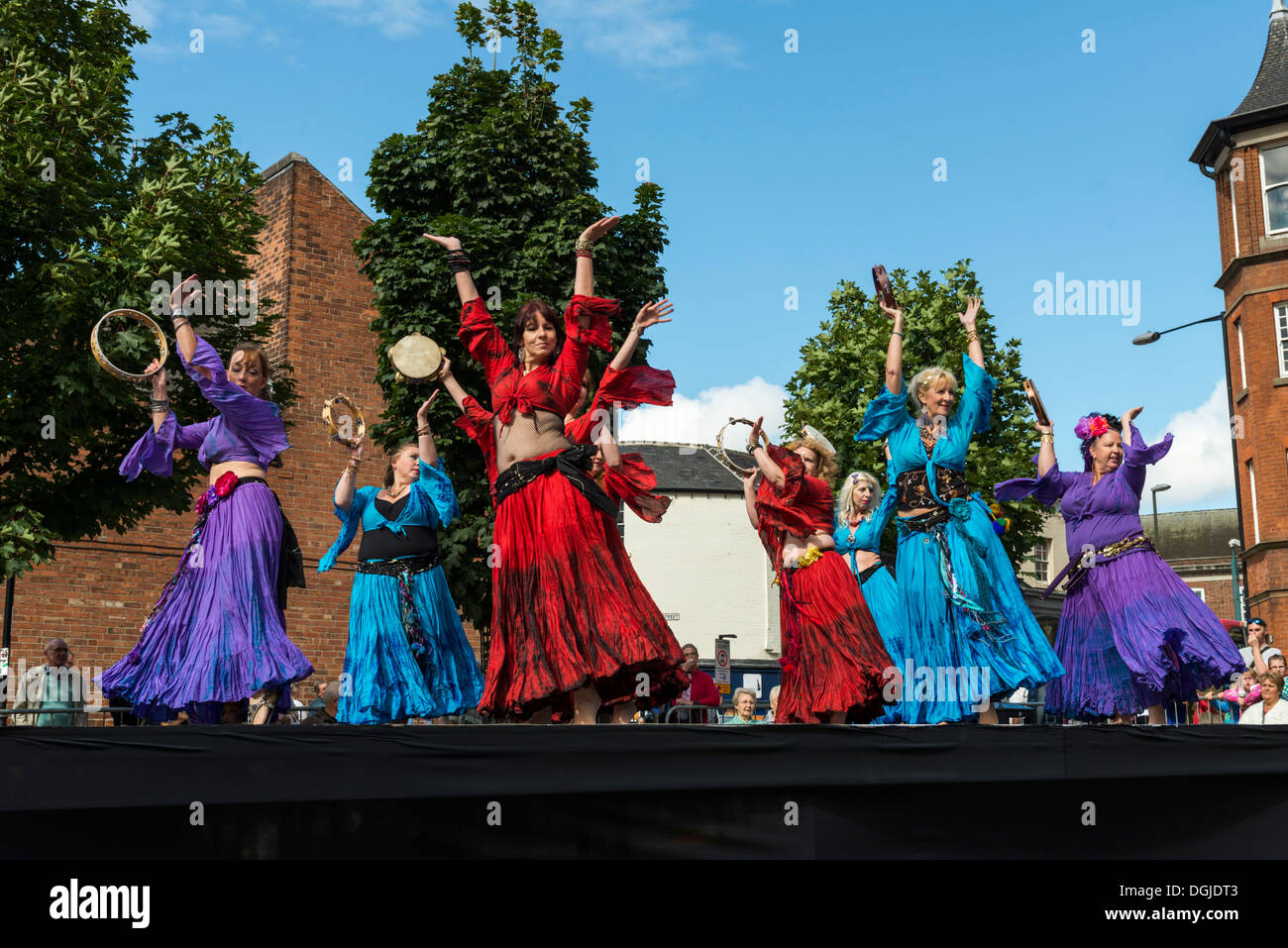 Women dancing on a stage in the open air wearing costumes Dance