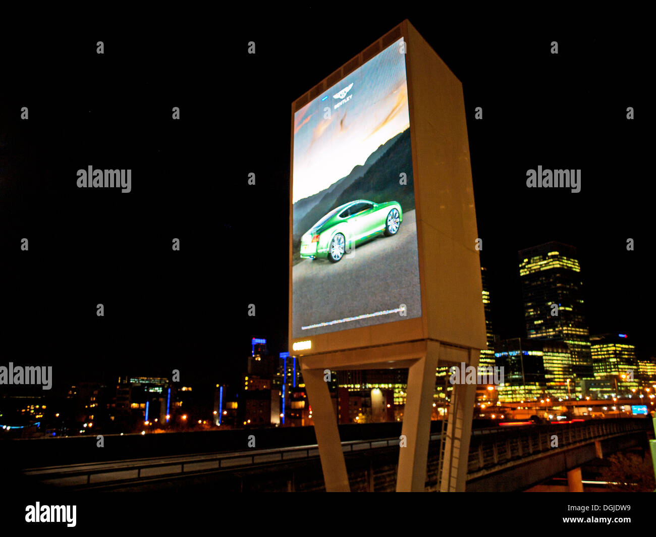 View of billboard at night showing Canary Wharf skyscrapers in