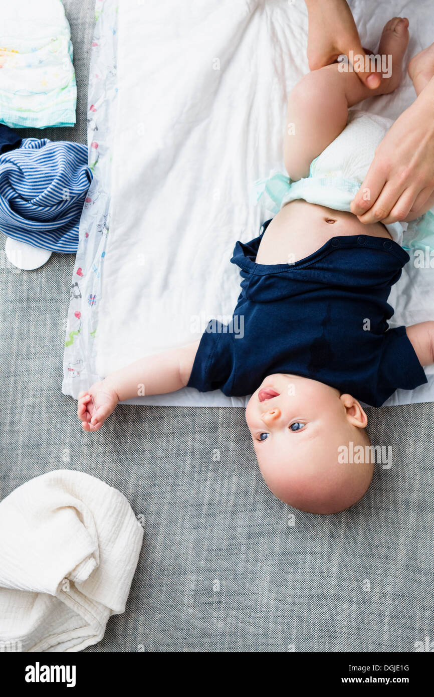 Person changing baby boy's nappy, overhead view Stock Photo