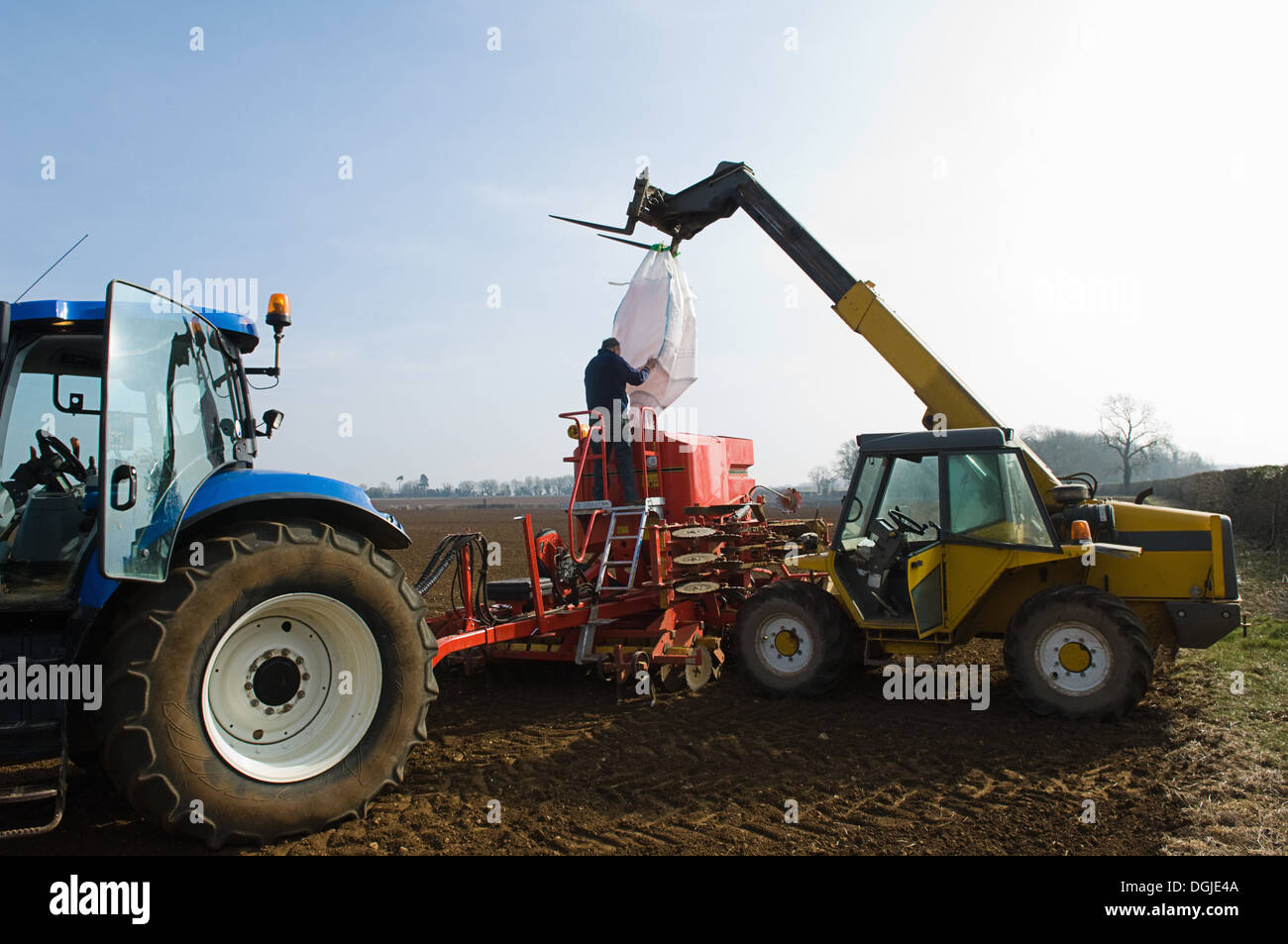 Farmer filling machinery with seed for planting Stock Photo