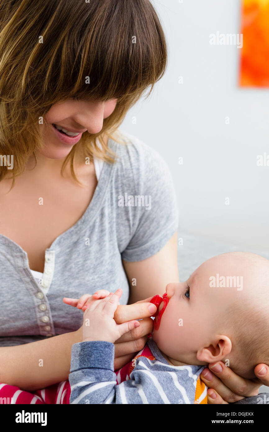 Mother and baby son with pacifier in mouth Stock Photo