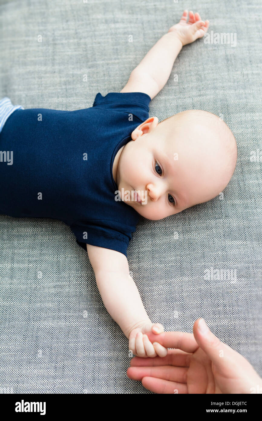 Baby boy holding person's hand Stock Photo