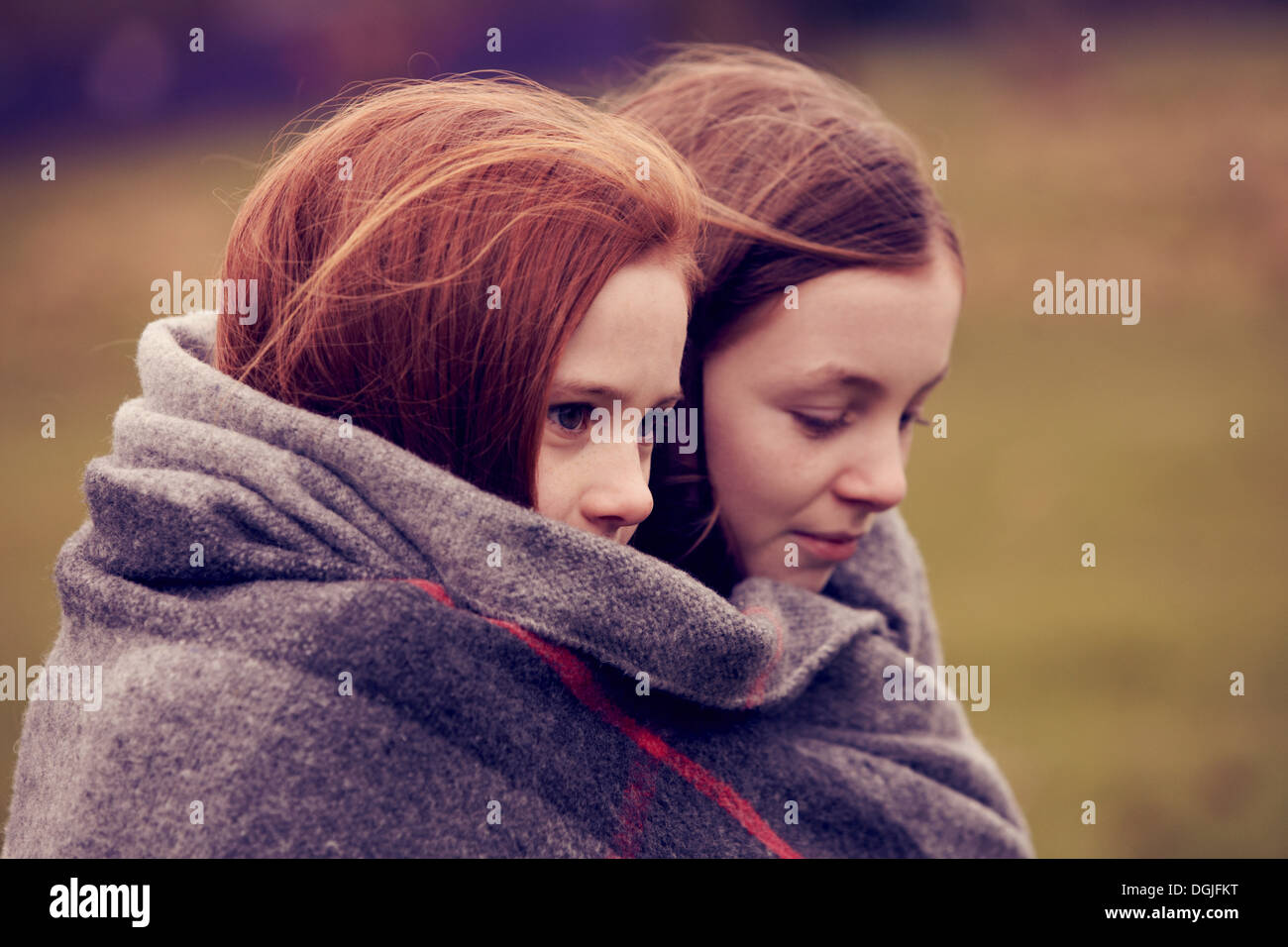Girls wrapped in a blanket outdoors Stock Photo