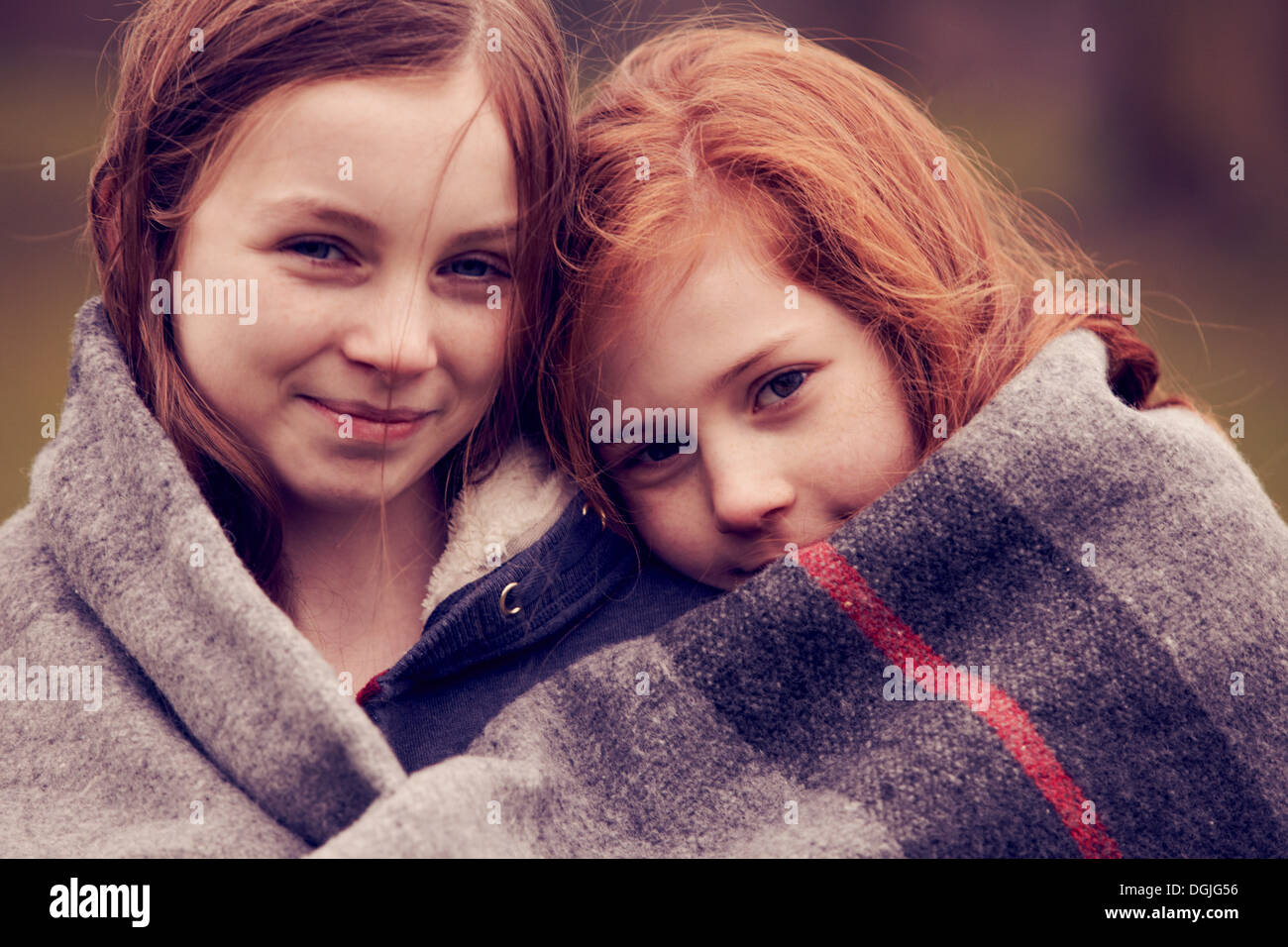Portrait of girls wrapped in a blanket outdoors Stock Photo