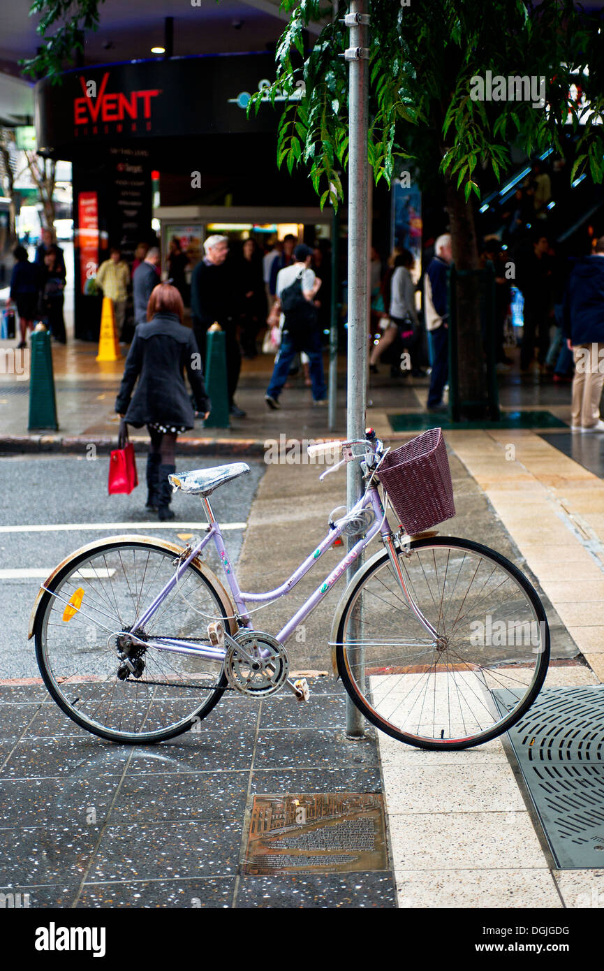 A ghost bicycle leaning against a post on a street in Brisbane. Stock Photo