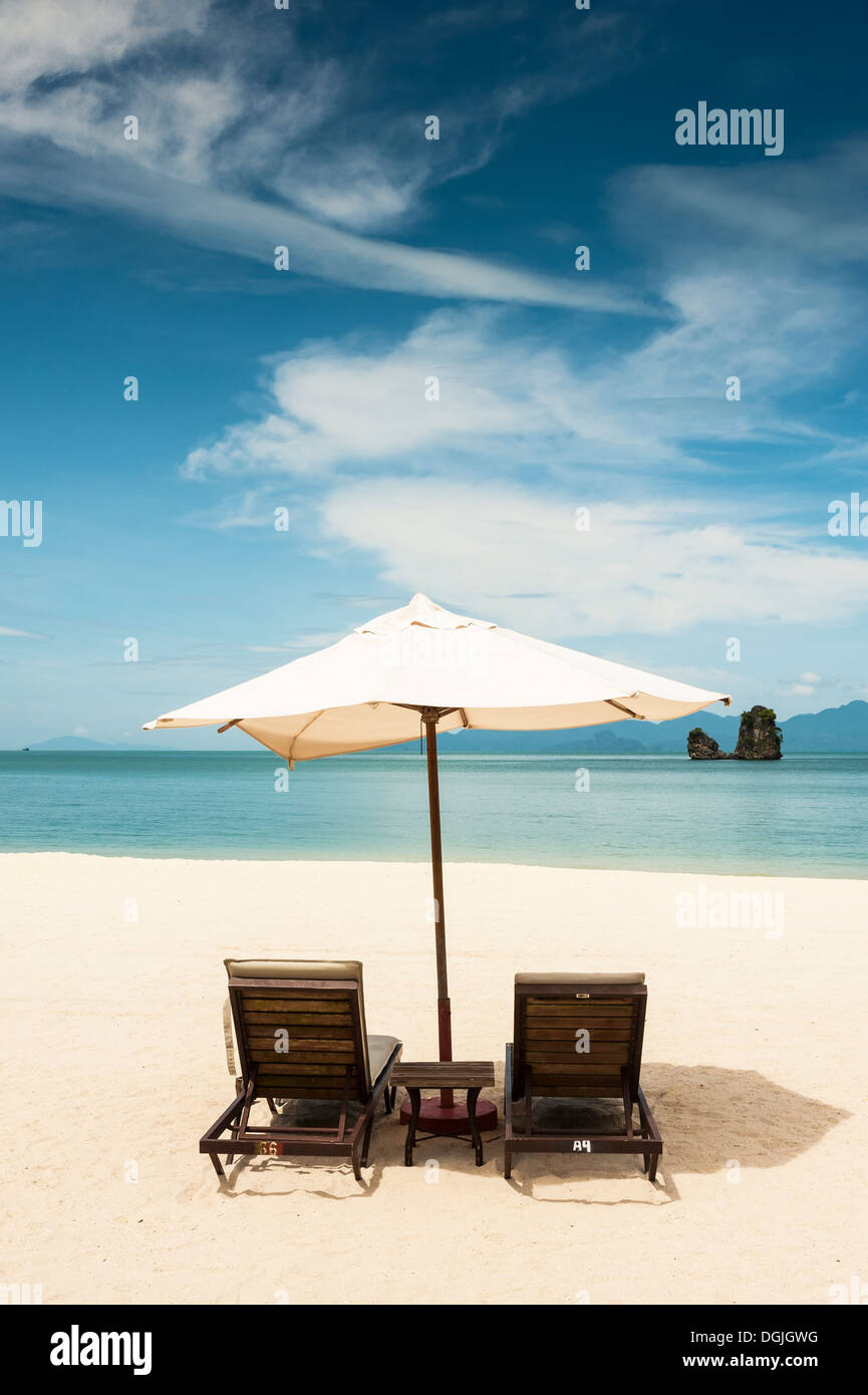 Two sunloungers and an umbrella on Tanjung Rhu beach in Langkawi. Stock Photo
