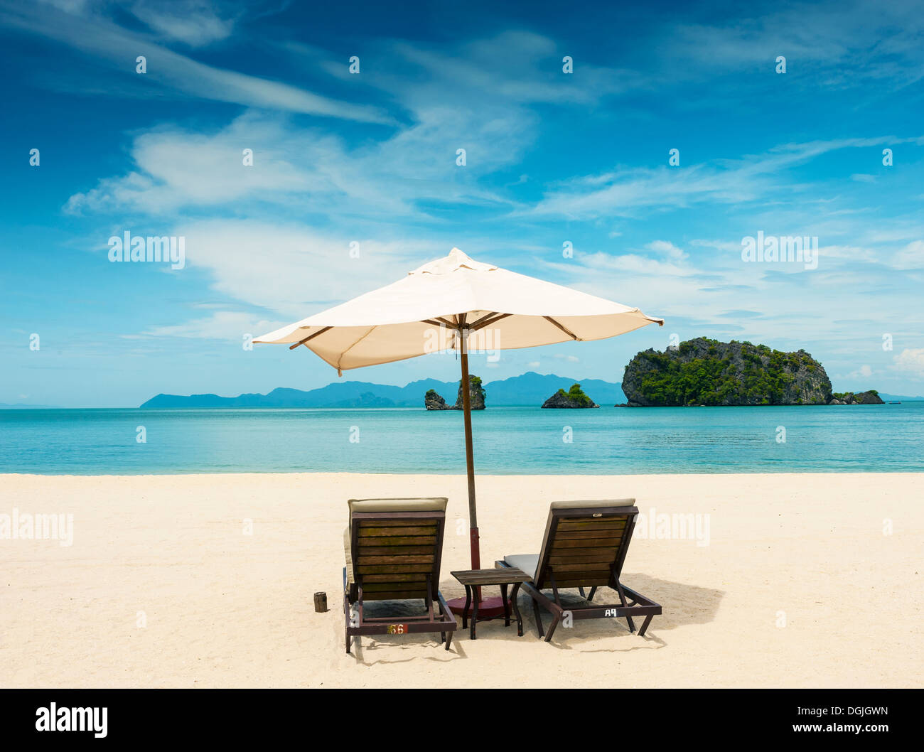 Two sunloungers and an umbrella on Tanjung Rhu beach in Langkawi. Stock Photo