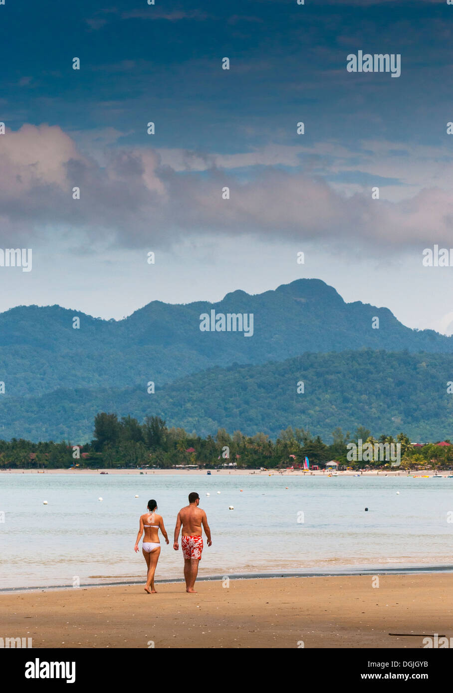 Two people walking along Pentai Tengah beach in Langkawi. Stock Photo
