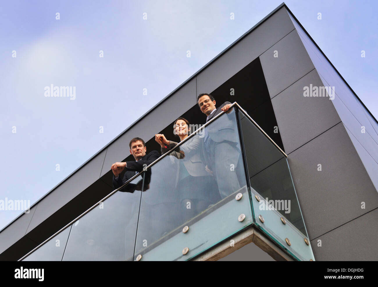 Three office colleagues on balcony, low angle Stock Photo