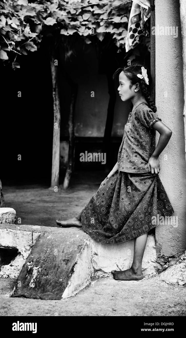 Indian lower caste girl standing in a house gateway. Andhra Pradesh, India. Black and White. Stock Photo