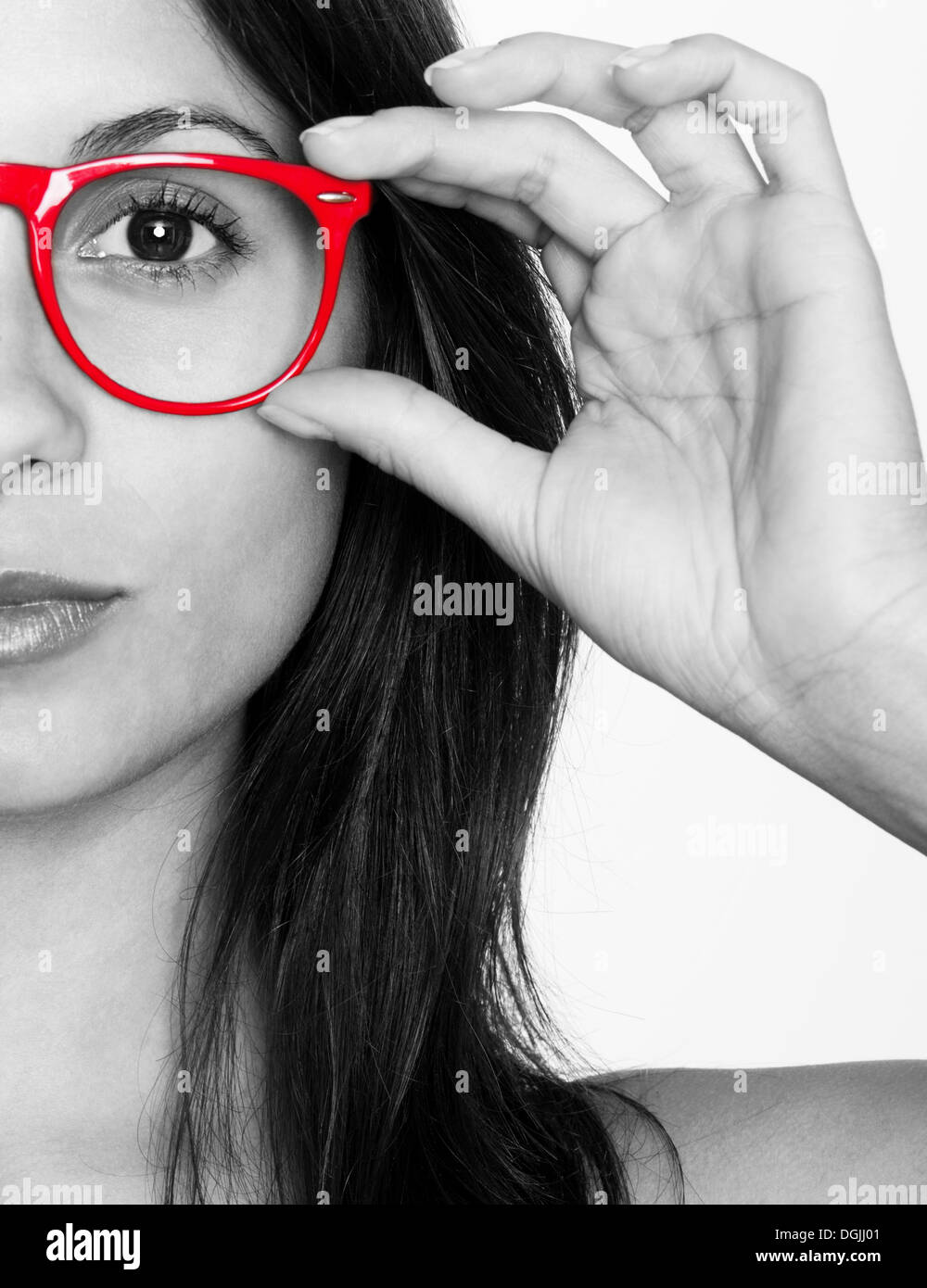 Half portrait of a young woman in black and white with red glasses Stock Photo