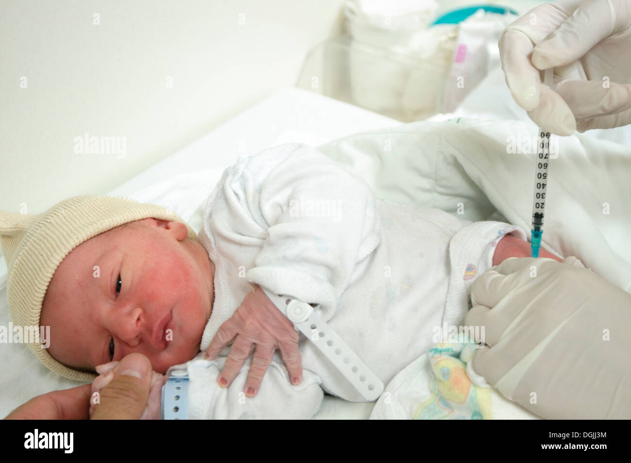 A one day old baby boy having his first injection - model release available Stock Photo