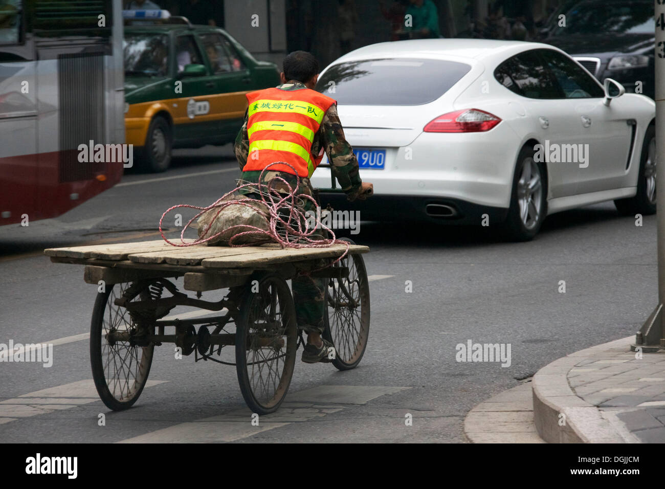 Old transport bicycle in front of a Porsche, Beijing, China, People's Republic of China Stock Photo