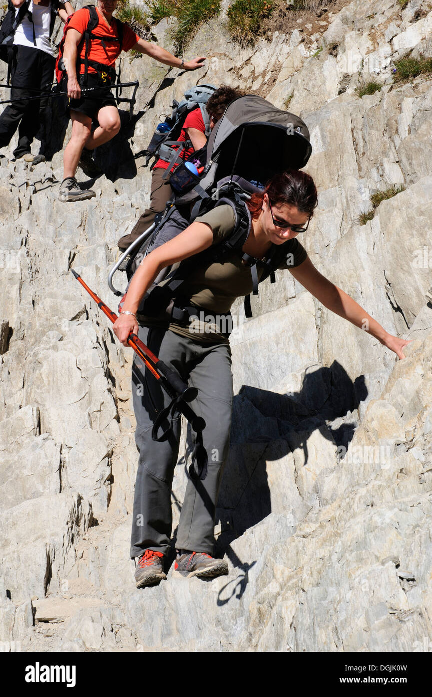 A lady hillwalker in the French Alps descending steep rock with her ...