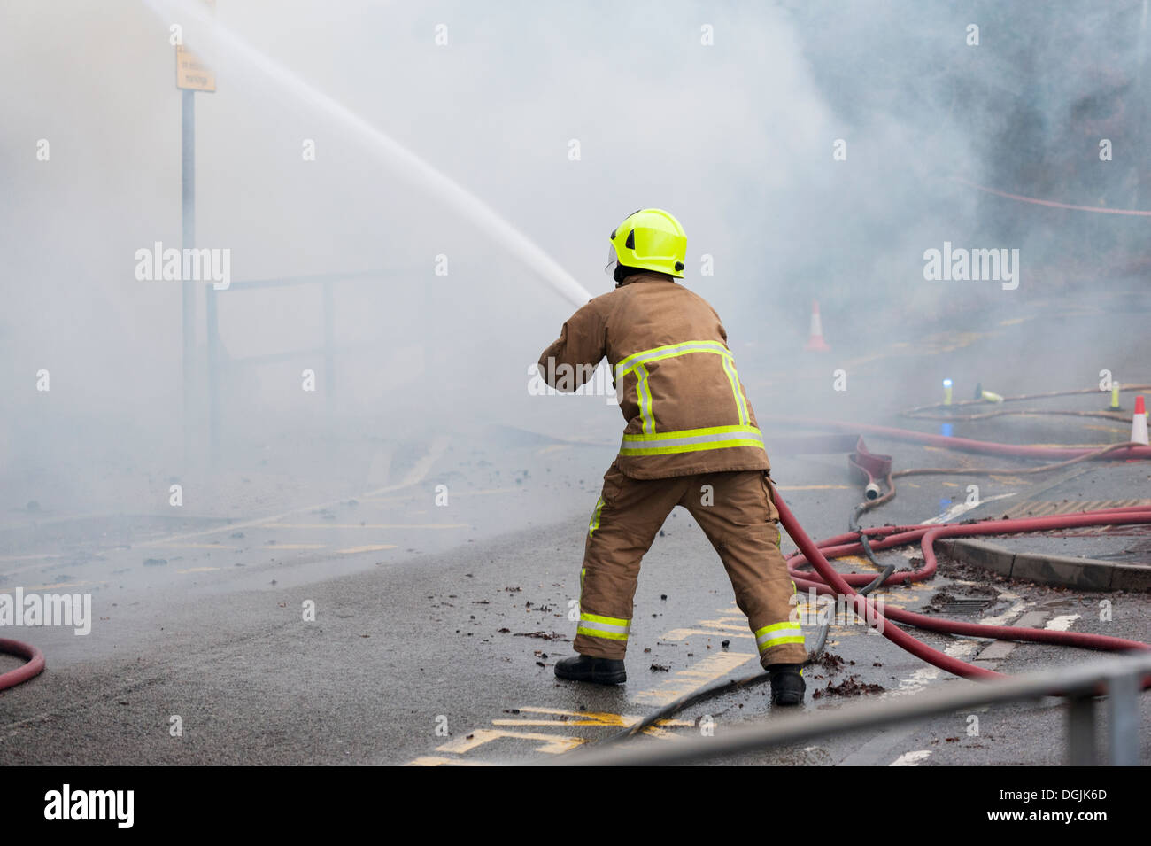 A member of the Essex Fire Service tackles a fire with a hose. Stock Photo