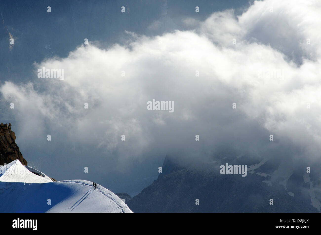 Tiny figures of two mountaineers dwarfed by their surroundings Stock Photo