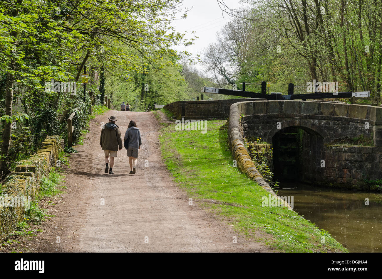 A couple waling along the path beside the Peak Forest Canal, Marple, Stockport, Greater Manchester, England Stock Photo