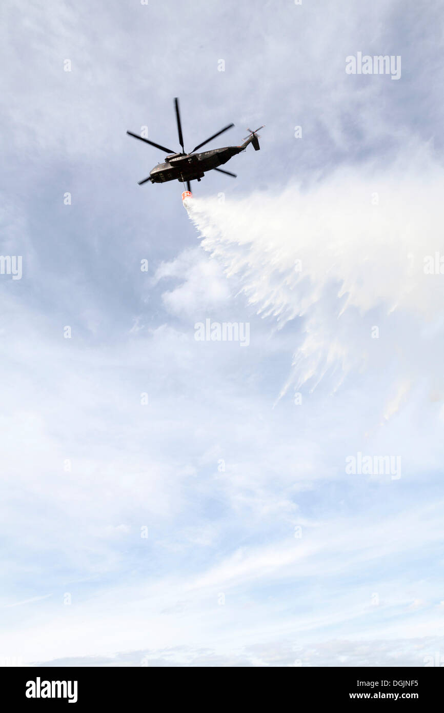 CH53 helicopter carrying a water tank during an exercise, dropping