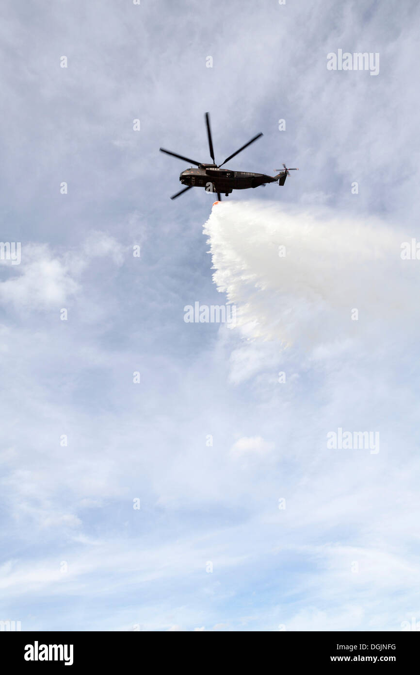 CH53 helicopter carrying a water tank during an exercise, dropping
