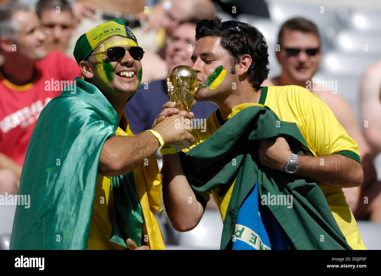 Brazilian football fans kissing a model of the World Cup, Football World Cup 2006 in Germany Stock Photo
