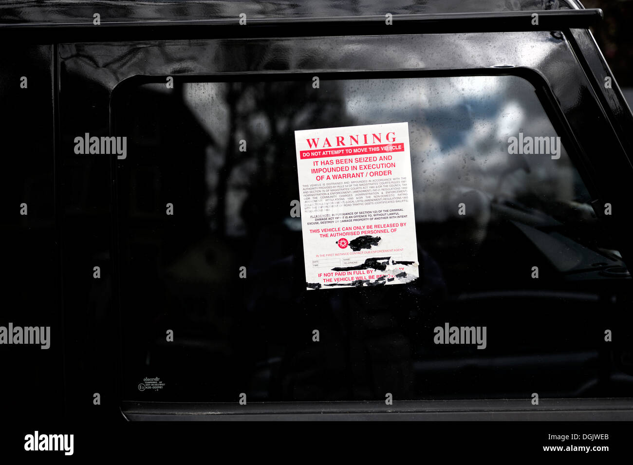 A warning notice stuck on the window of an illegally parked vehicle. Stock Photo