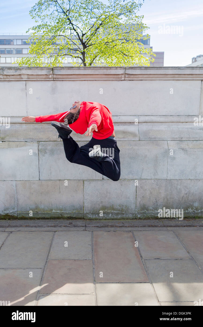 Young male dancer mid air in city Stock Photo