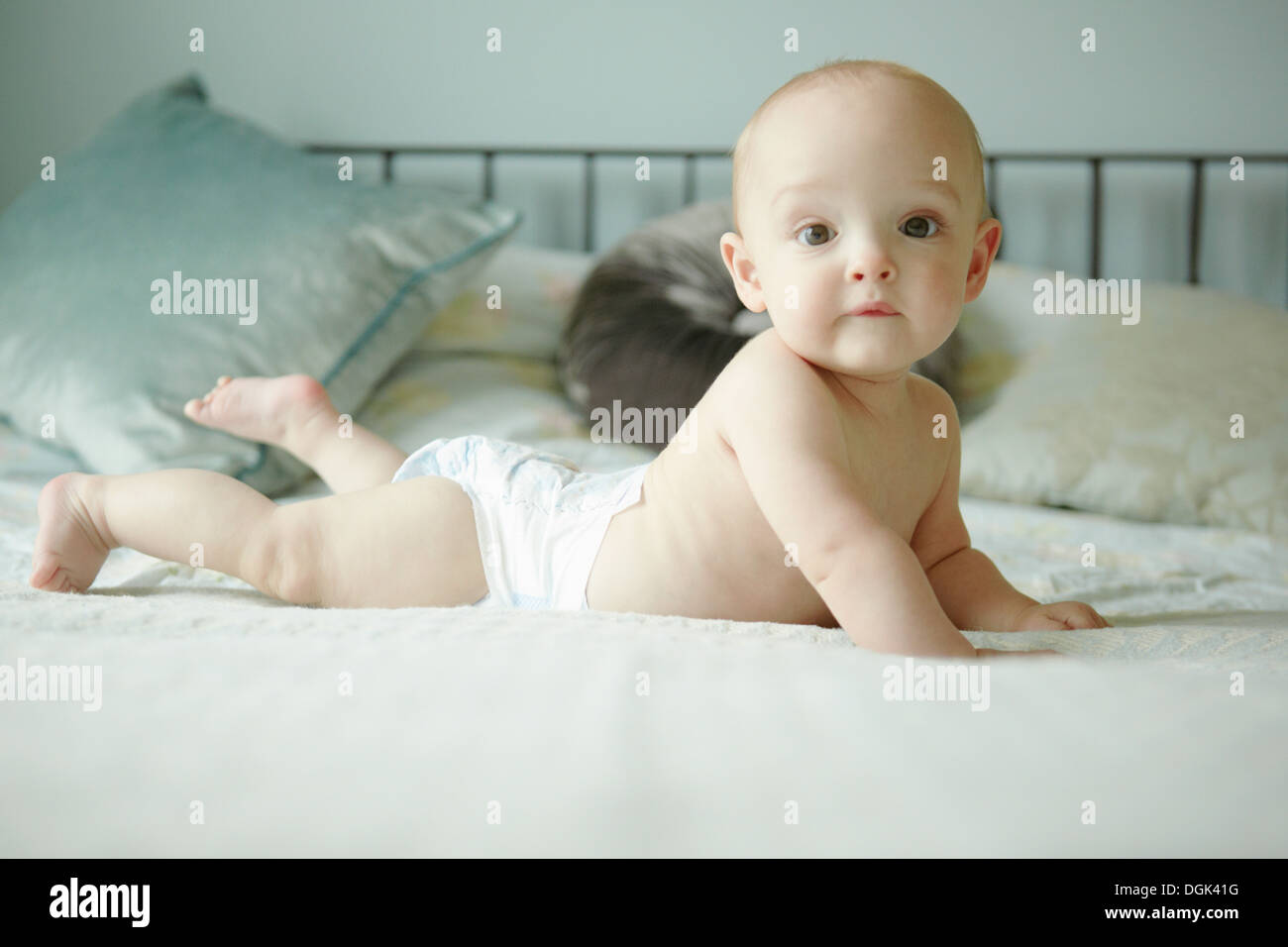 Baby boy lying on front on bed Stock Photo