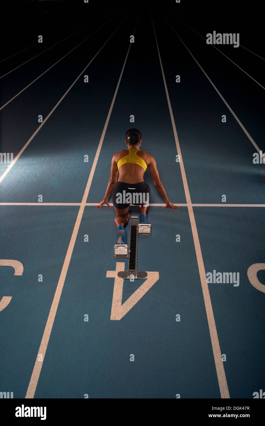 Young female athlete on starting blocks, high angle Stock Photo