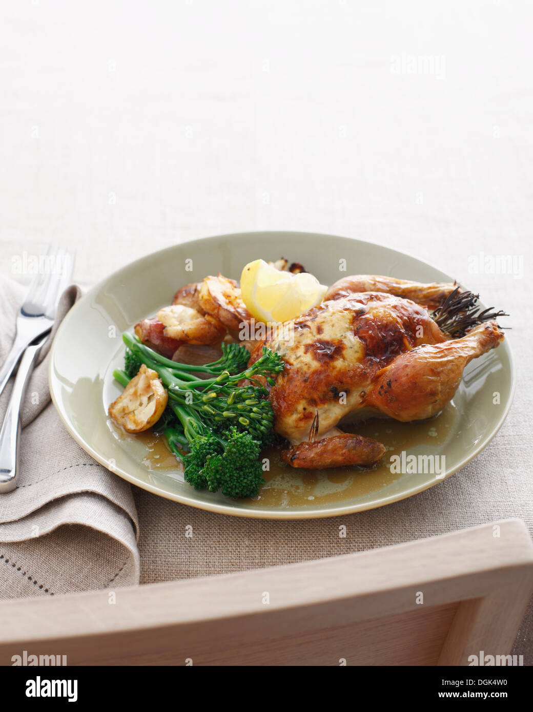 Roast spatchcock with broccolini and roast potatoes Stock Photo