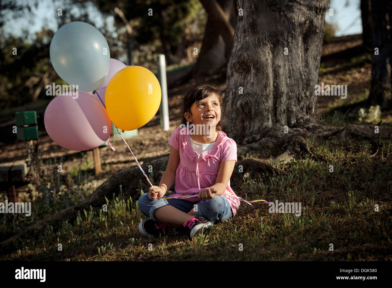 Girl on grass holding balloons Stock Photo - Alamy