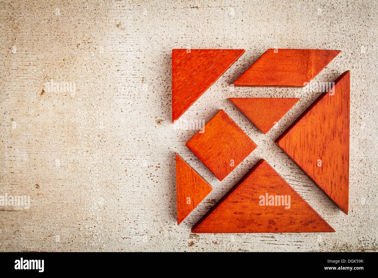 seven tangram wooden pieces, a traditional Chinese puzzle game, rough white painted barn wood background Stock Photo