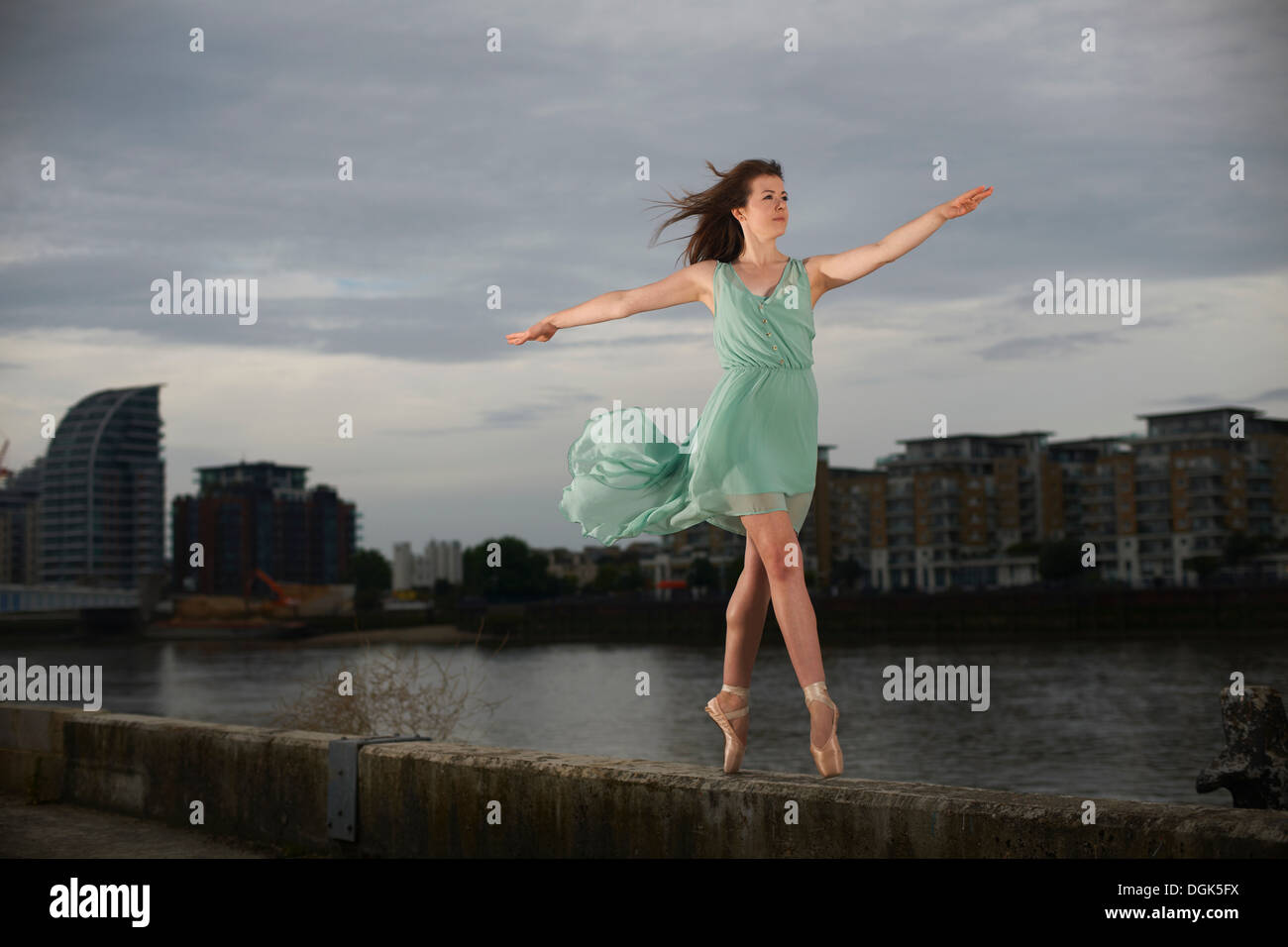 Ballet dancer standing on tiptoe on wall Stock Photo