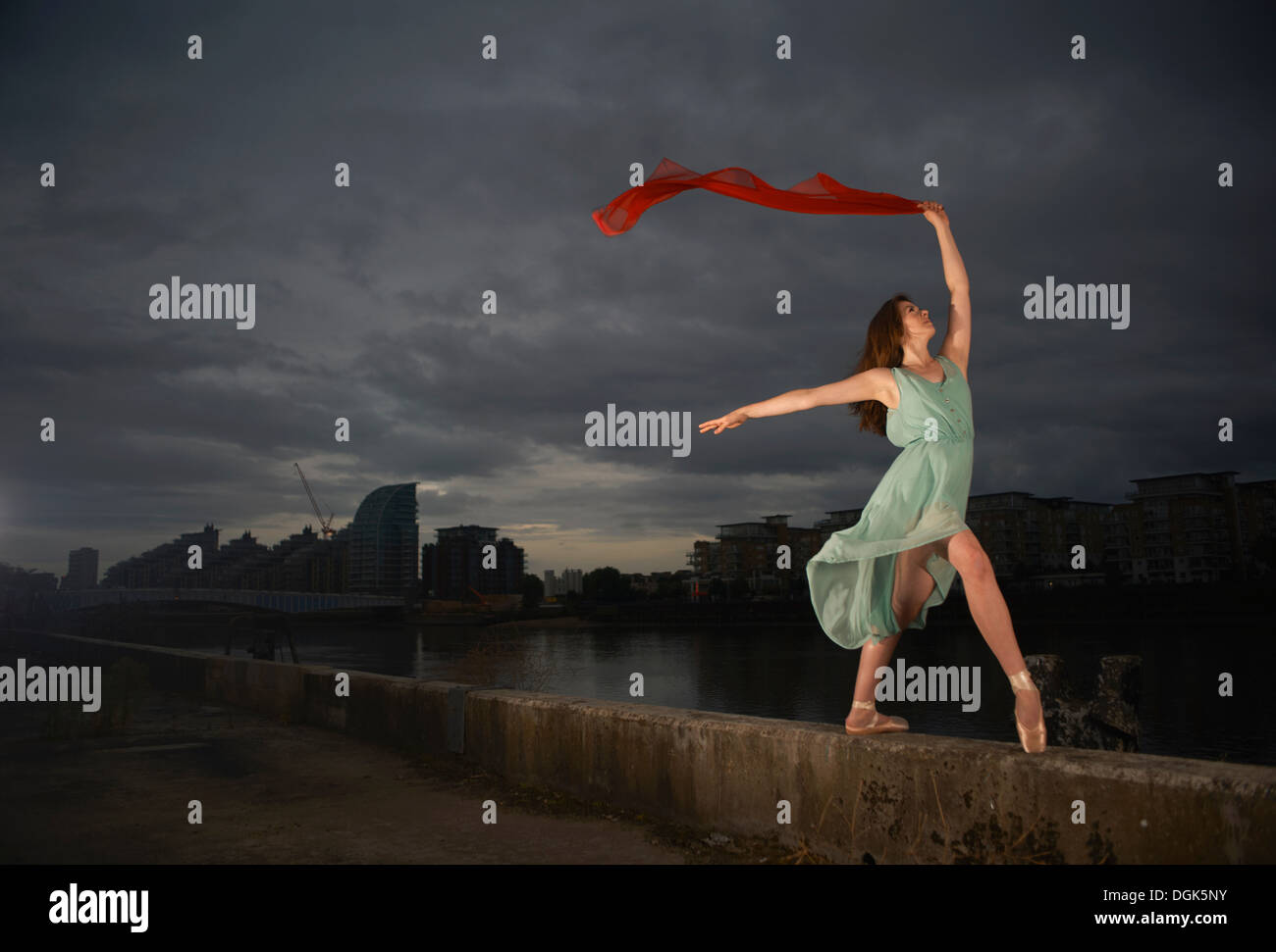 Ballet dancer holding red scarf on wall Stock Photo