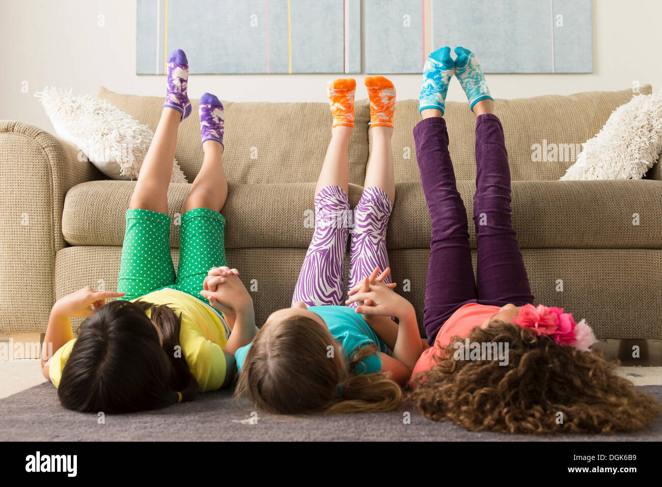 Three girls lying on floor with legs up Stock Photo - Alamy
