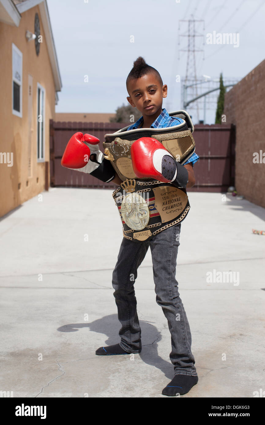 Boy wearing boxing gloves with medals Stock Photo