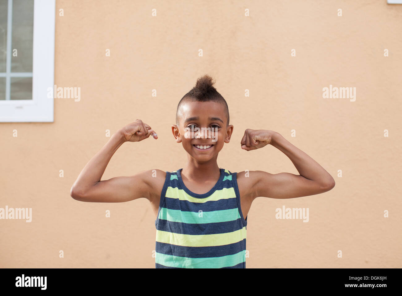 Portrait of boy flexing muscles Stock Photo