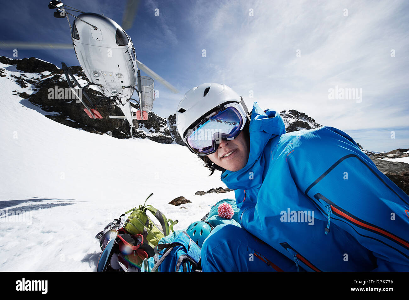 Skiing couple with rescue helicopter overhead Stock Photo