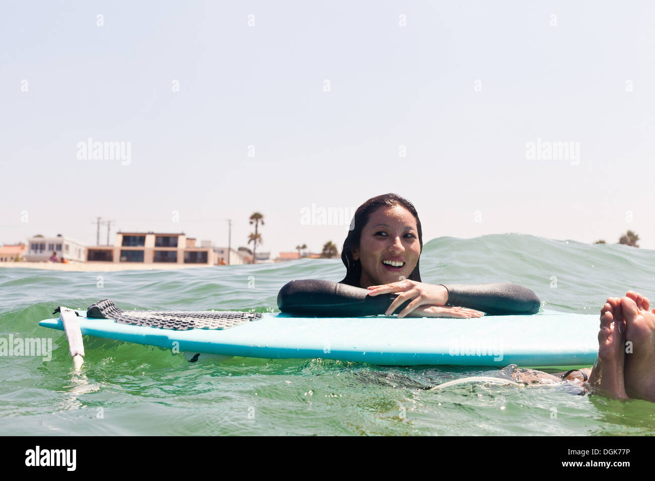 Woman floating with surfboard, Hermosa Beach, California, USA Stock Photo