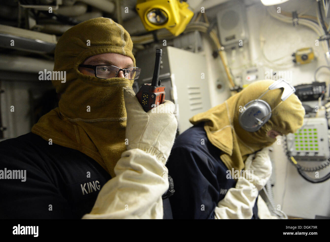 Damage Controlman 3rd Class Dennis King, assigned to the Ticonderoga-class guided-missile cruiser USS Antietam (CG 54), communicates with one of the ship's fire teams from a repair locker during a damage control drill. Antietam is on patrol with the Georg Stock Photo