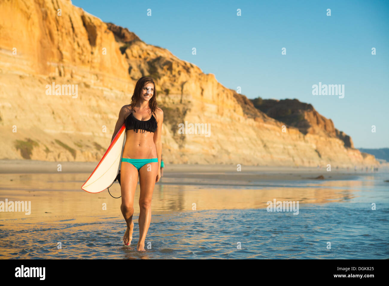 Young woman walking with surfboard, La Jolla, San Diego, California, USA Stock Photo
