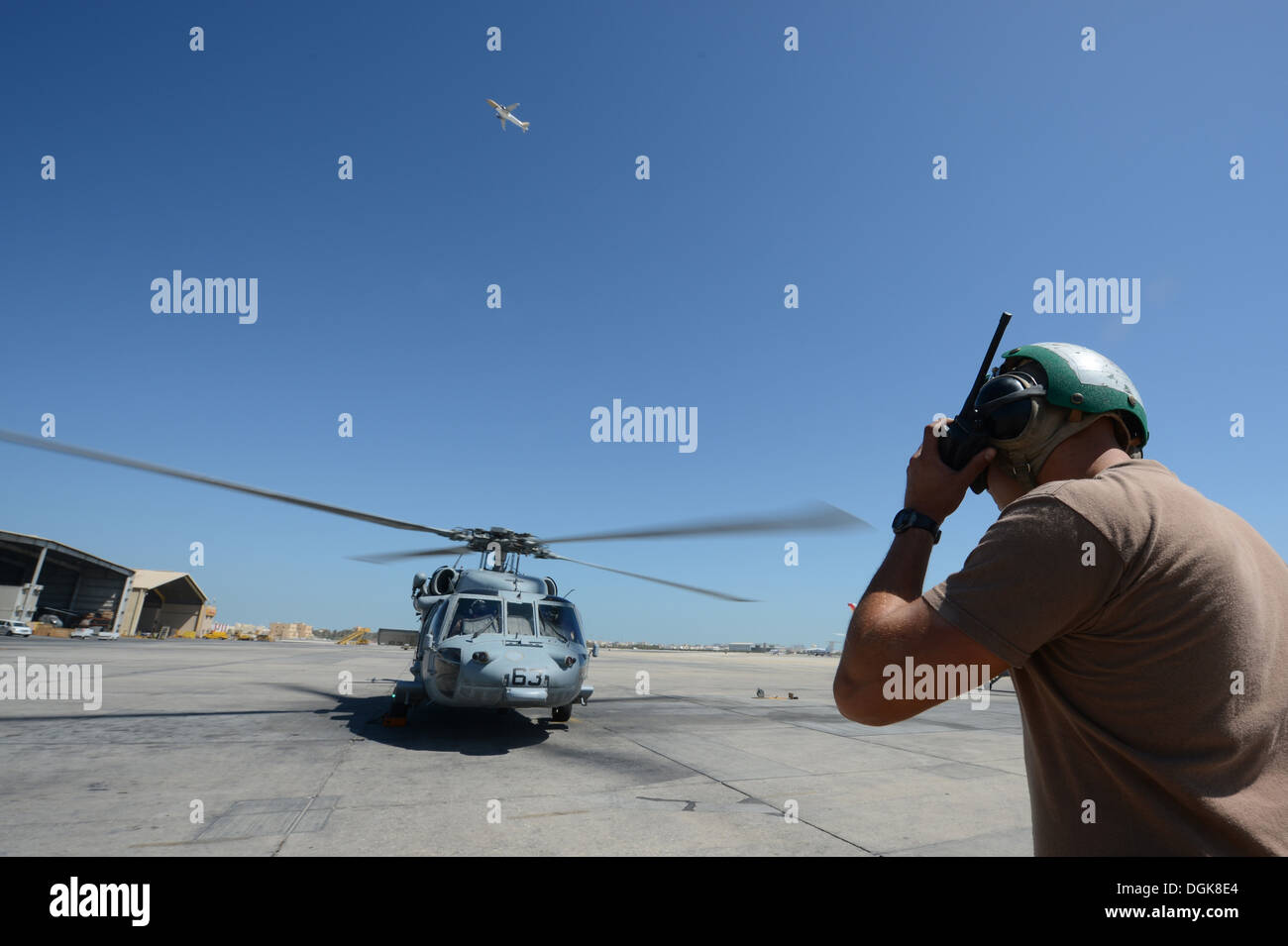 Sailor assigned to Helicopter Sea Combat Squadron (HSC) 26 maintains radio communications with the pilot of an MH-60S Seahawk h Stock Photo